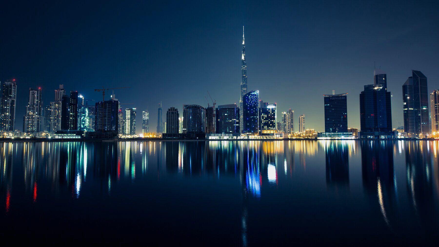 Business Bay, Dubai, at night, its towers reflected in the water of the canal