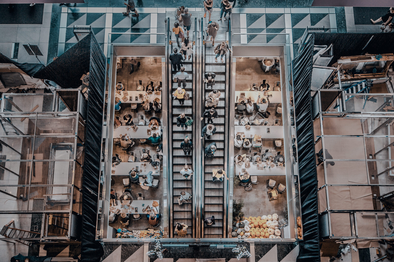 Overhead view of a retail atrium, with escalators running between occupied floors