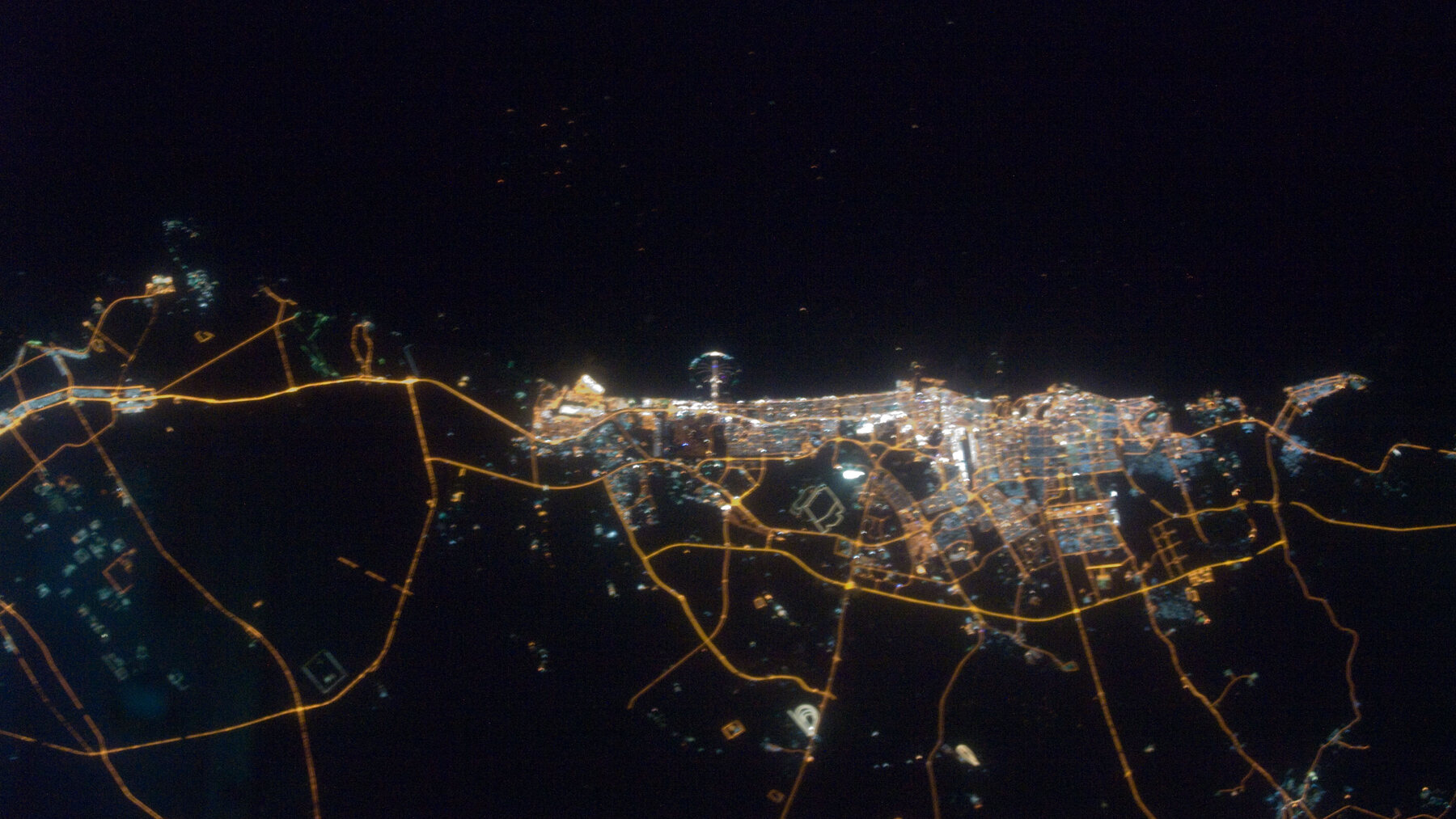 Dubai at night from above, the density in which Ellington's buildings compete on finish rather than scale