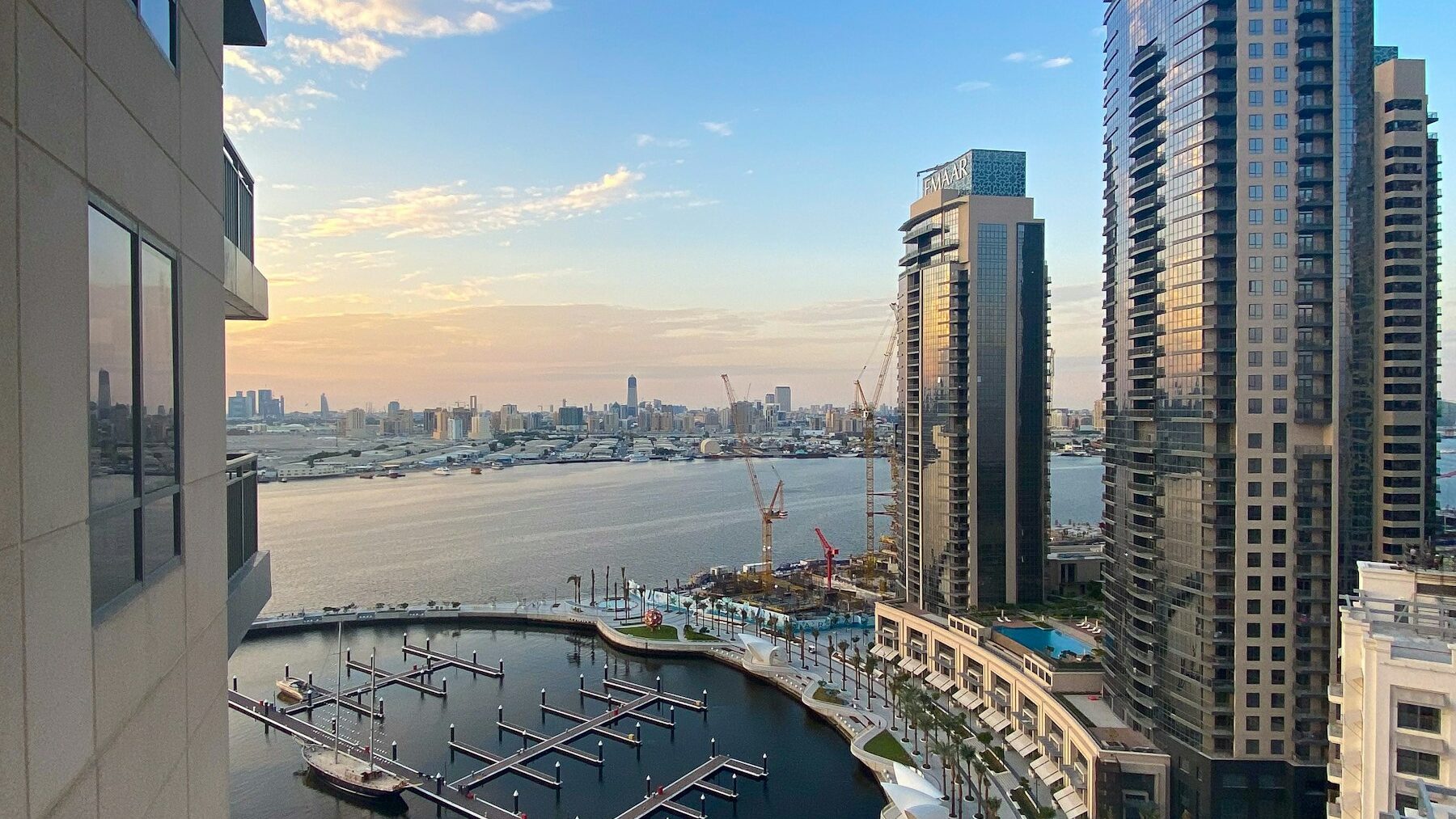 Waterfront residential towers overlooking a Dubai creek at sunset