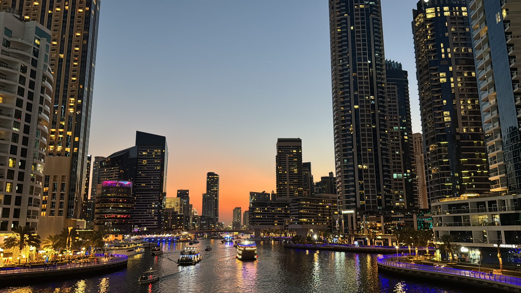 Dubai's marina skyline at dusk — the market Ras Al Khaimah is priced at a discount to, about ninety minutes south